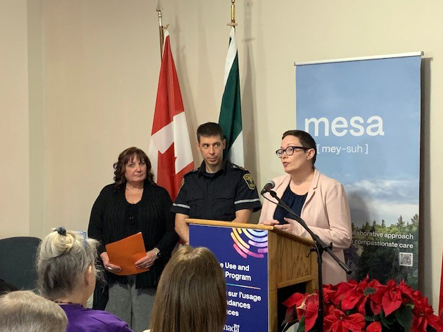 speakers at a podium during funding announcement