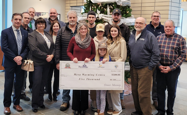 Group of people standing with a large cheque