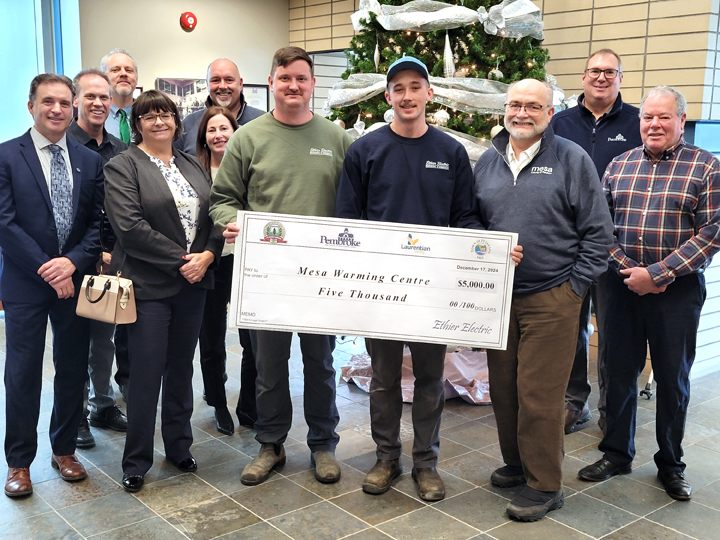 Group of people standing with a large cheque